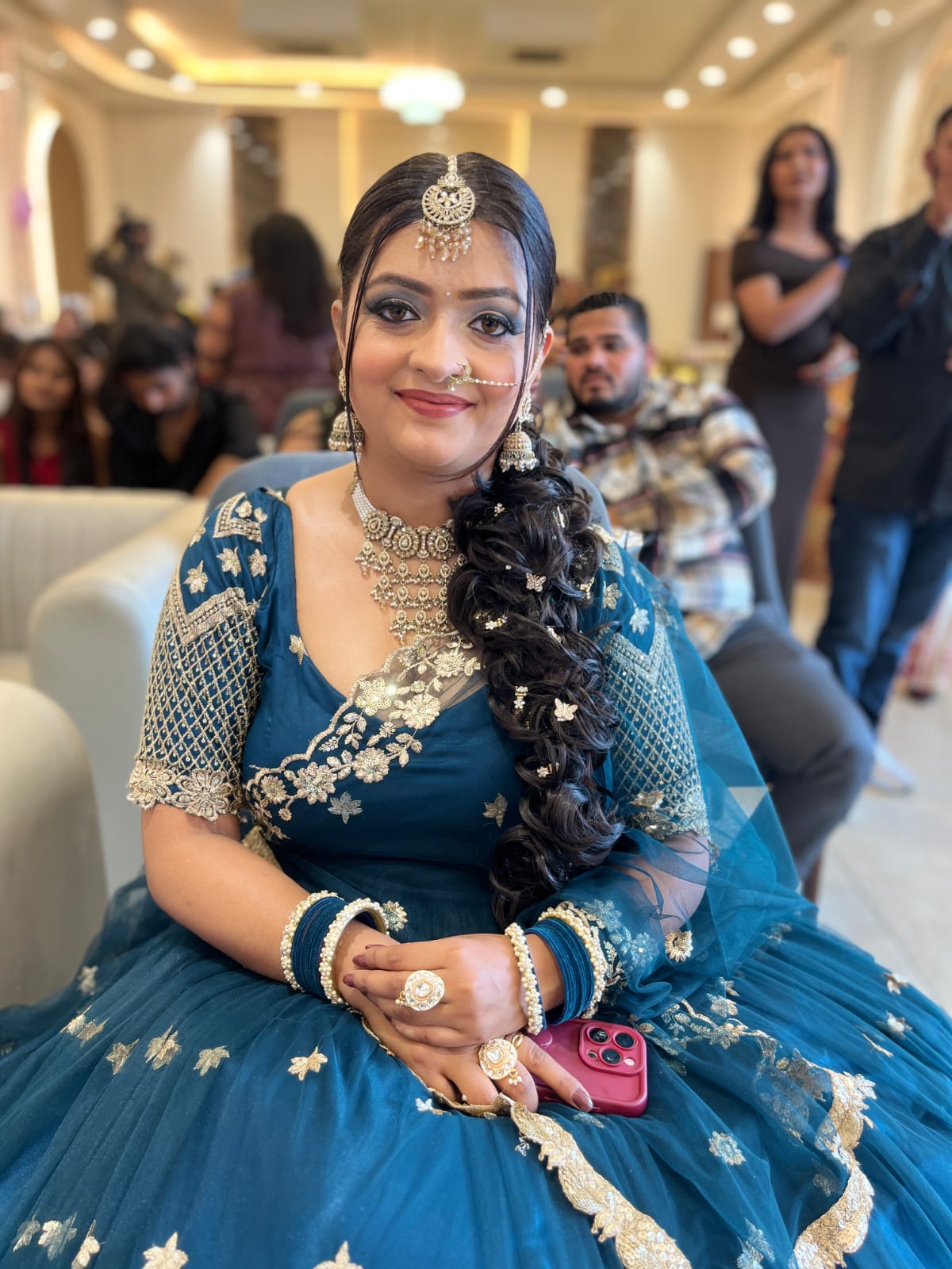 Bridal makeup look with blue attire and braided hairstyle.