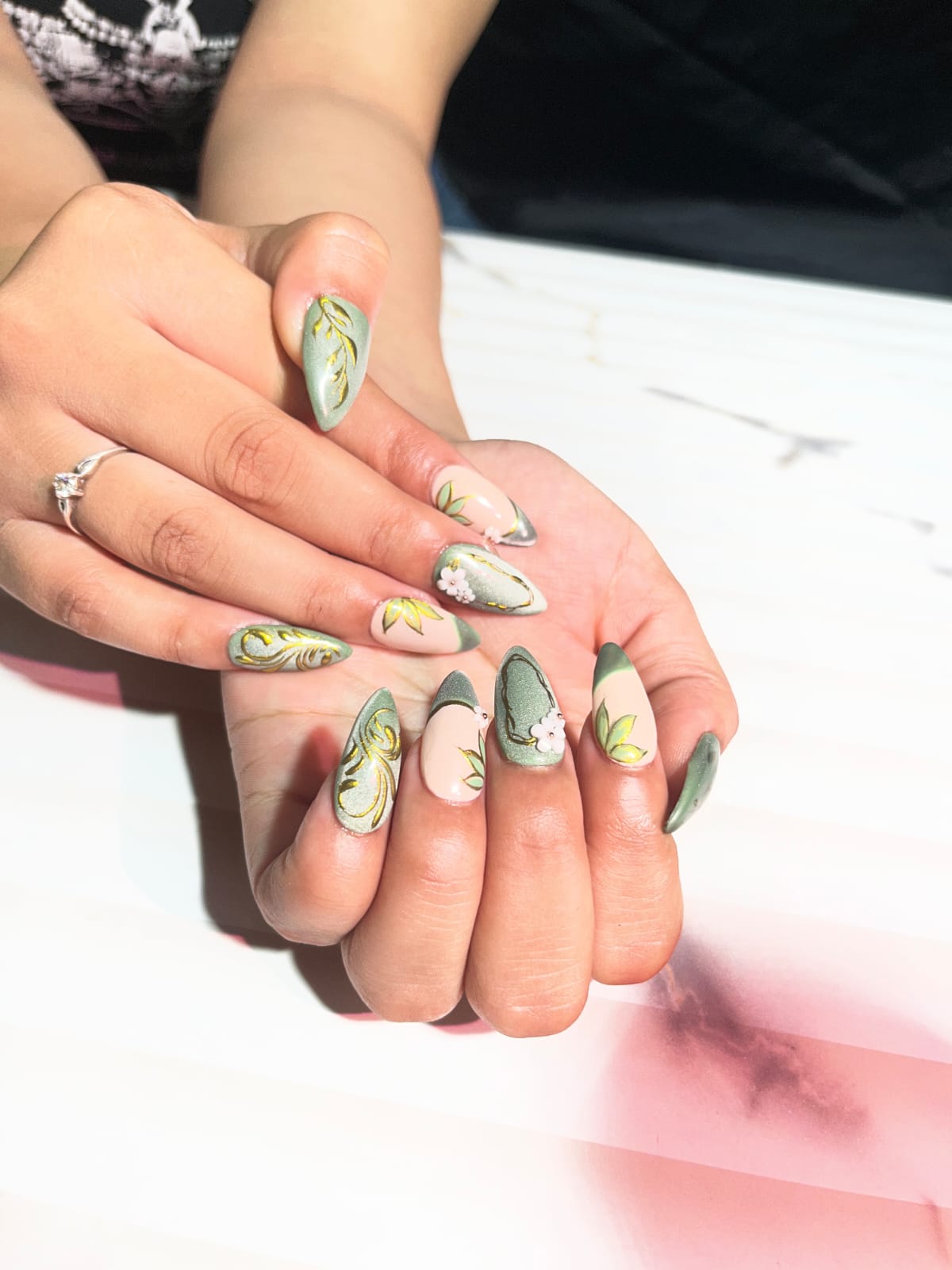 Green, gold and floral nail art finish.